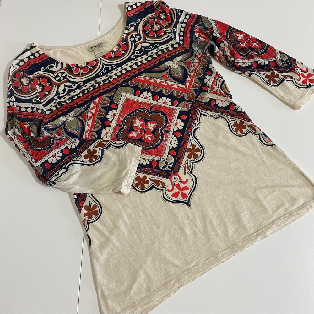 Intricate red and navy print cream top.